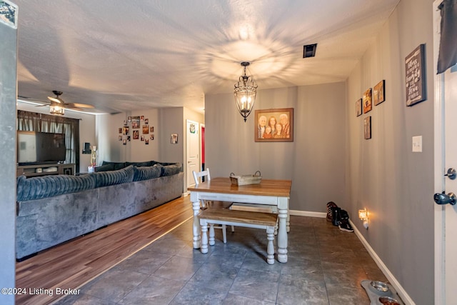 dining area featuring ceiling fan with notable chandelier and dark hardwood / wood-style flooring