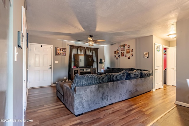 living room with ceiling fan, hardwood / wood-style floors, and a textured ceiling