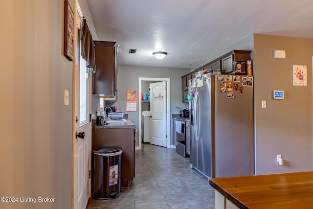 kitchen with light tile patterned floors, dark brown cabinetry, a textured ceiling, and appliances with stainless steel finishes