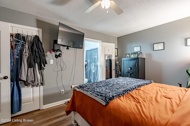 bedroom with a textured ceiling, ceiling fan, dark hardwood / wood-style flooring, and ensuite bathroom