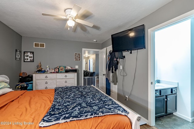 bedroom with connected bathroom, ceiling fan, and a textured ceiling