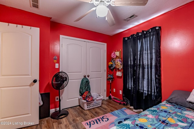 bedroom with ceiling fan, a closet, and wood-type flooring