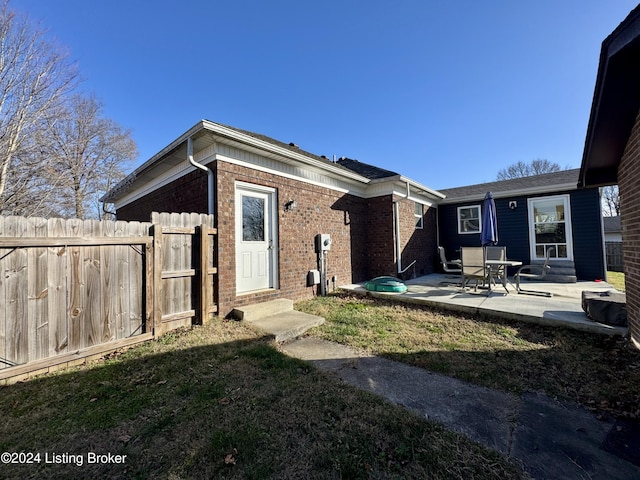 back of property with a patio area and a yard