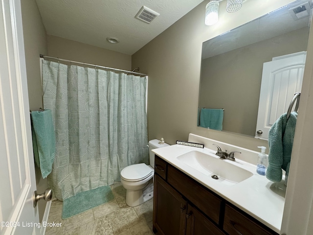 bathroom featuring vanity, a textured ceiling, and toilet