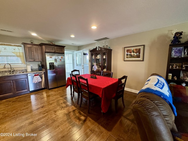 dining area featuring hardwood / wood-style flooring, sink, and washer / clothes dryer