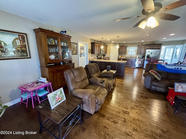 living room with ceiling fan, dark hardwood / wood-style flooring, and sink