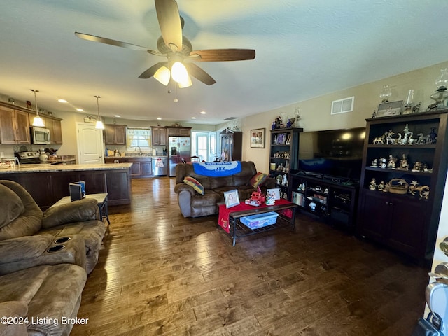 living room with dark hardwood / wood-style floors and ceiling fan