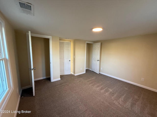 unfurnished bedroom with dark colored carpet