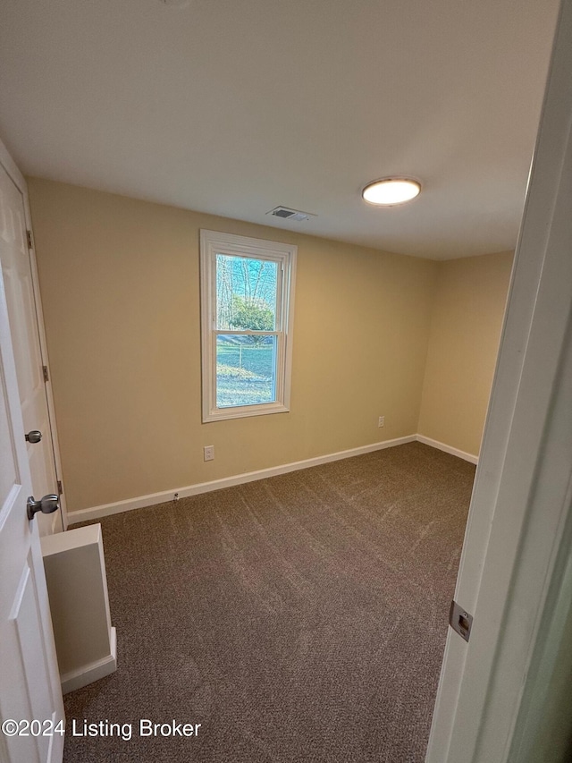 empty room with dark colored carpet