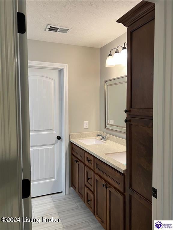 bathroom with vanity and a textured ceiling