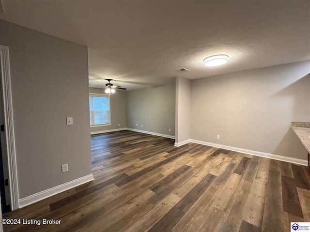 unfurnished room featuring ceiling fan and dark wood-type flooring