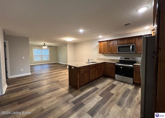 kitchen featuring kitchen peninsula, sink, dark hardwood / wood-style floors, and appliances with stainless steel finishes