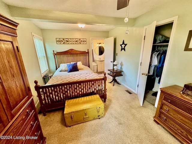 carpeted bedroom with ensuite bathroom, a spacious closet, and a closet