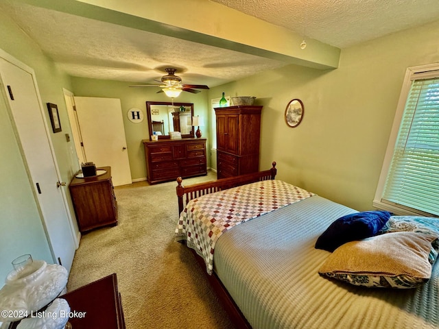 carpeted bedroom featuring a textured ceiling and ceiling fan