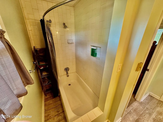 bathroom featuring hardwood / wood-style flooring and shower / tub combo with curtain