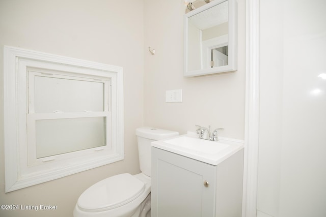 half bathroom featuring vanity and toilet