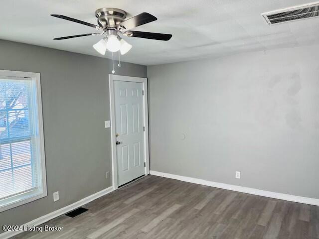 unfurnished room featuring ceiling fan and dark wood-type flooring