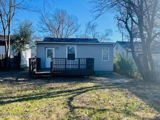 back of house featuring a wooden deck and a yard