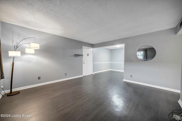 interior space with a textured ceiling and dark hardwood / wood-style floors