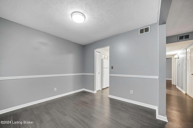 unfurnished room with a textured ceiling and dark wood-type flooring