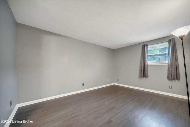 empty room with dark wood-type flooring