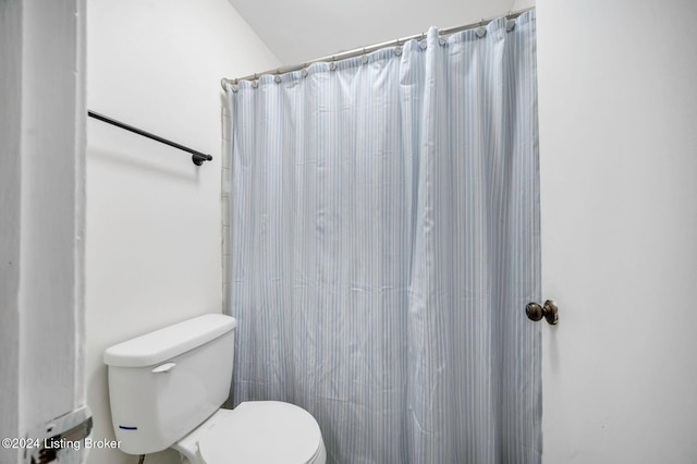 bathroom featuring a shower with curtain and toilet