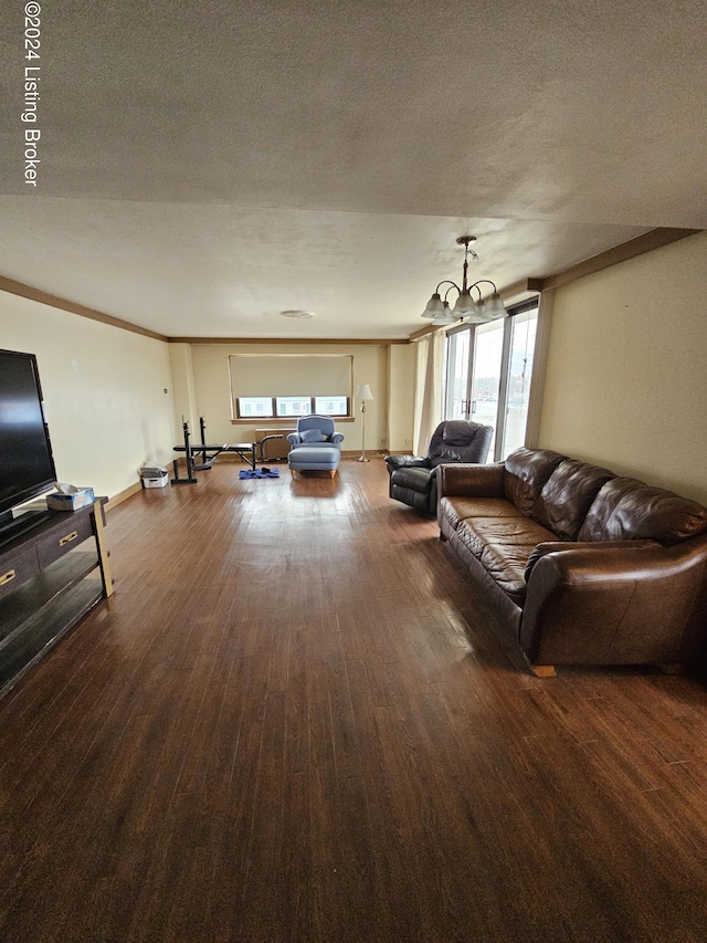 living room with a wealth of natural light, hardwood / wood-style floors, a textured ceiling, and an inviting chandelier