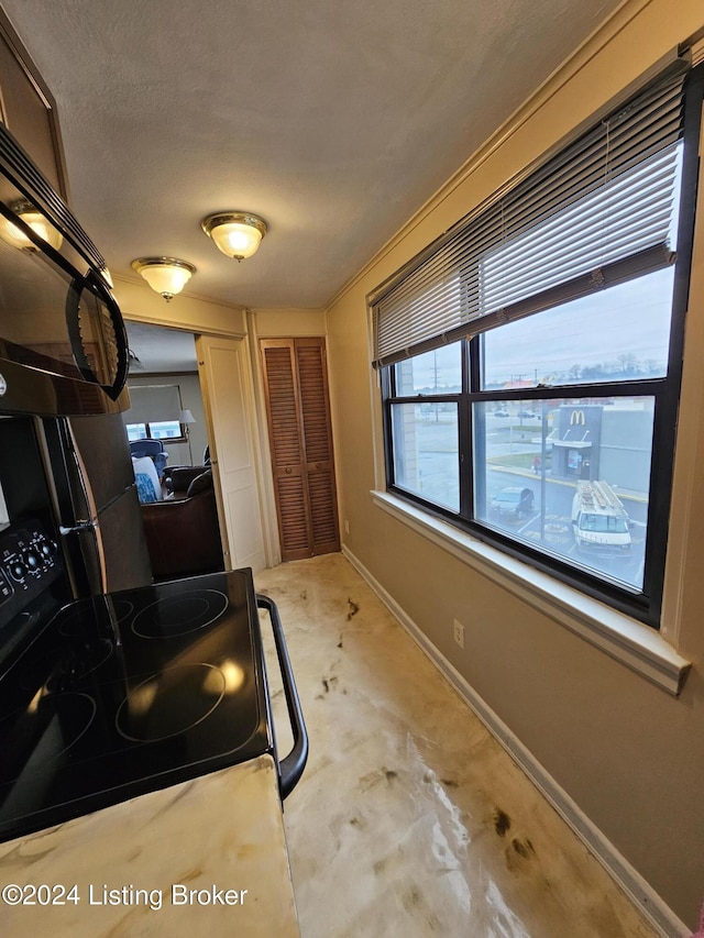 interior space featuring a textured ceiling and black electric range oven