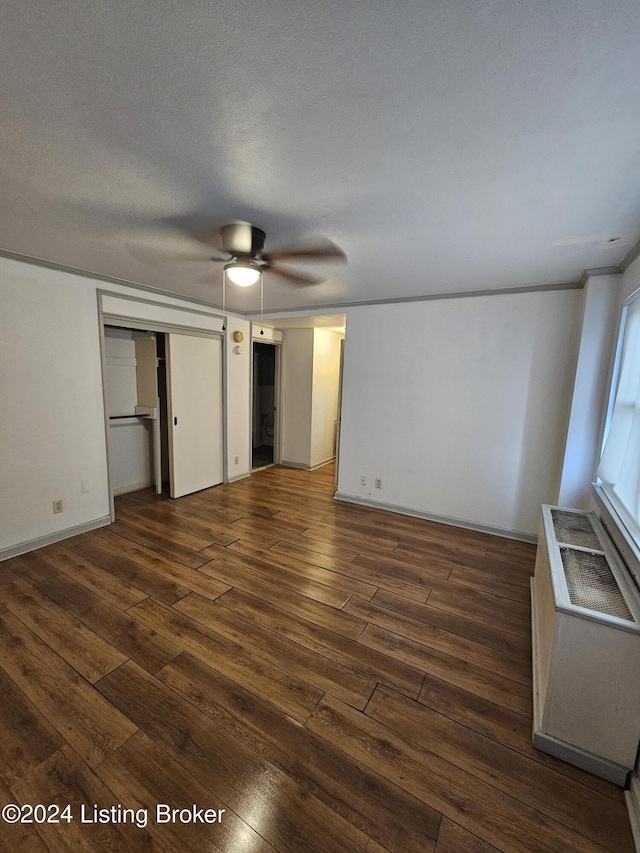 unfurnished bedroom with a textured ceiling, ceiling fan, a closet, and dark hardwood / wood-style floors