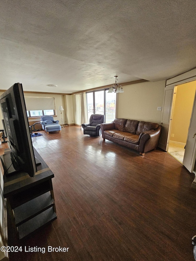 living room with hardwood / wood-style floors, a textured ceiling, and a notable chandelier