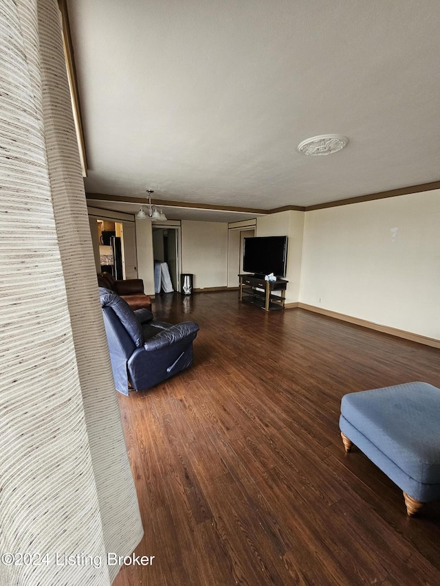 living room with dark hardwood / wood-style flooring, an inviting chandelier, and ornamental molding