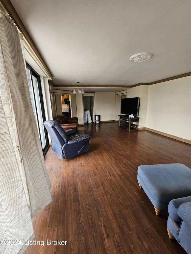 living room featuring a chandelier, hardwood / wood-style flooring, and ornamental molding