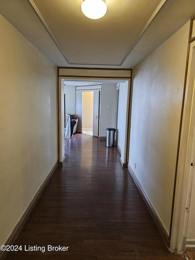 hall featuring a textured ceiling and dark hardwood / wood-style floors