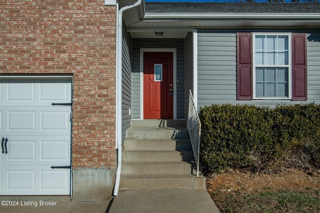 property entrance featuring brick siding and roof with shingles