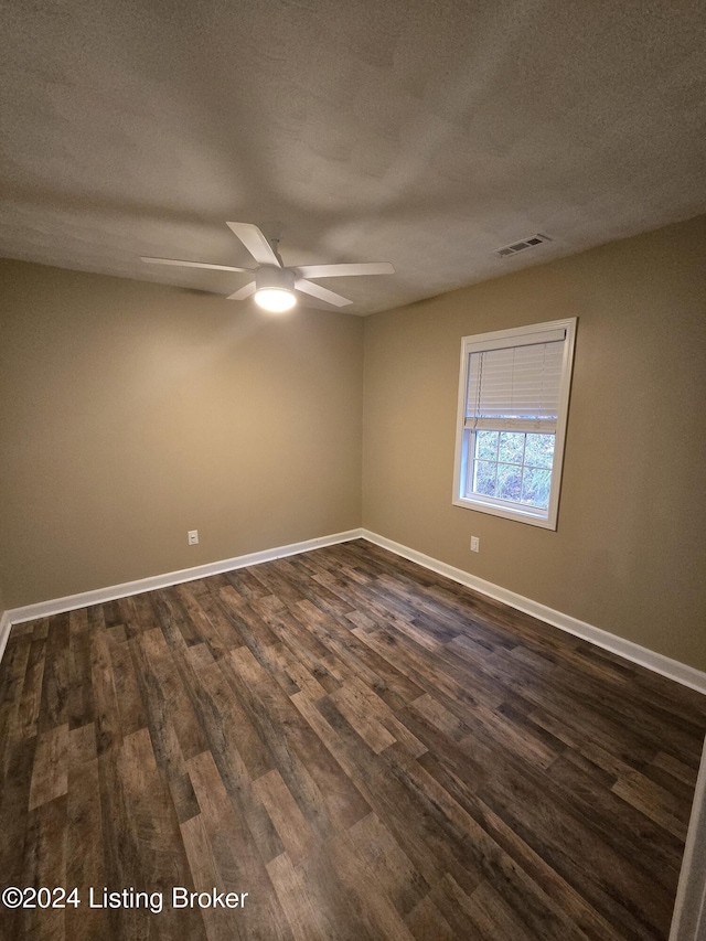 spare room featuring a textured ceiling, ceiling fan, and dark wood-type flooring