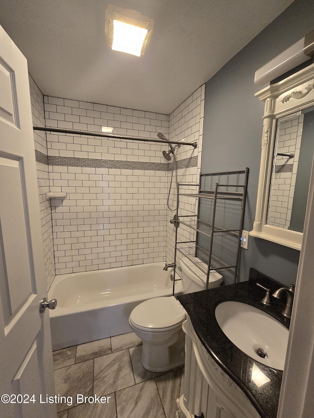 full bathroom with toilet, vanity, and tiled shower / bath