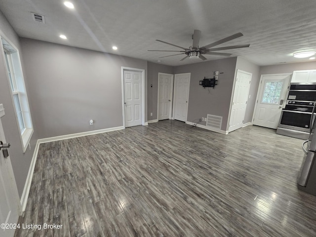 unfurnished living room with wood-type flooring, a textured ceiling, and ceiling fan