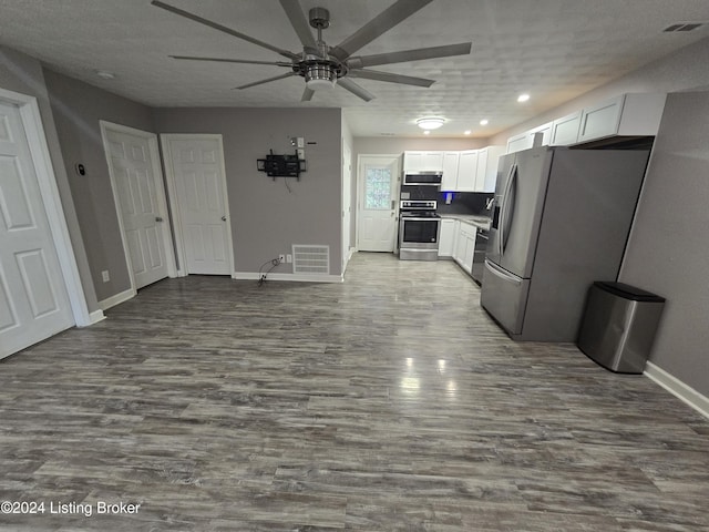 kitchen featuring hardwood / wood-style floors, white cabinets, ceiling fan, a textured ceiling, and stainless steel appliances