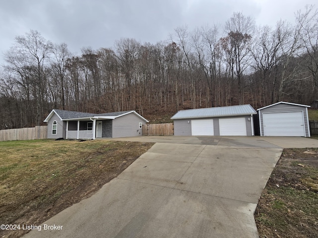 single story home with a garage, a front lawn, and an outdoor structure