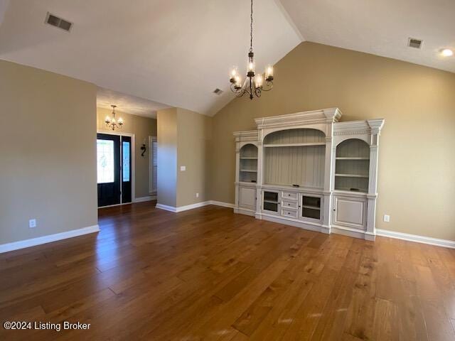 unfurnished living room with dark hardwood / wood-style flooring, vaulted ceiling, and a notable chandelier