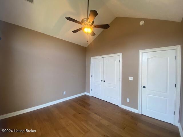 unfurnished bedroom with dark hardwood / wood-style floors, vaulted ceiling, and ceiling fan