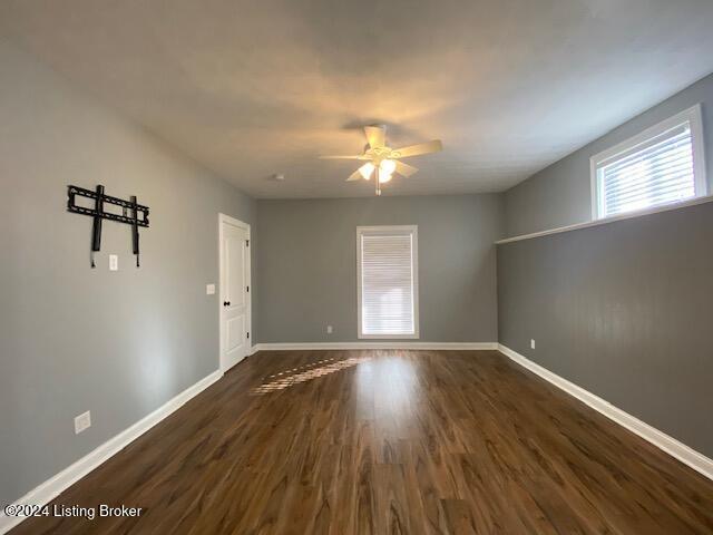 spare room with ceiling fan and dark hardwood / wood-style flooring