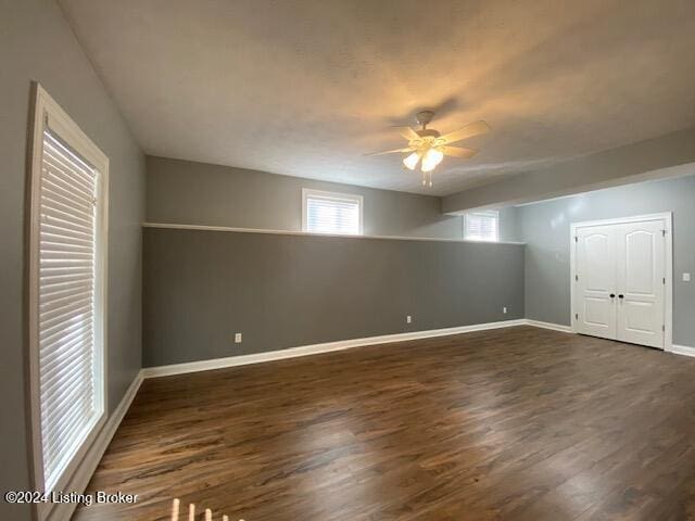 unfurnished room with ceiling fan and dark hardwood / wood-style flooring