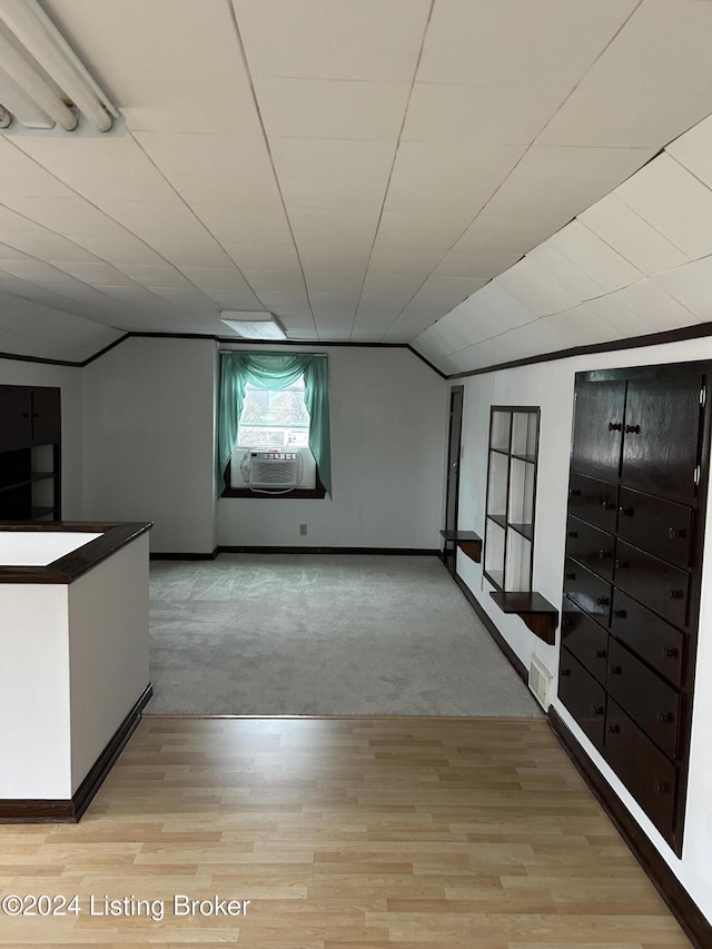 interior space with light carpet, cooling unit, and lofted ceiling