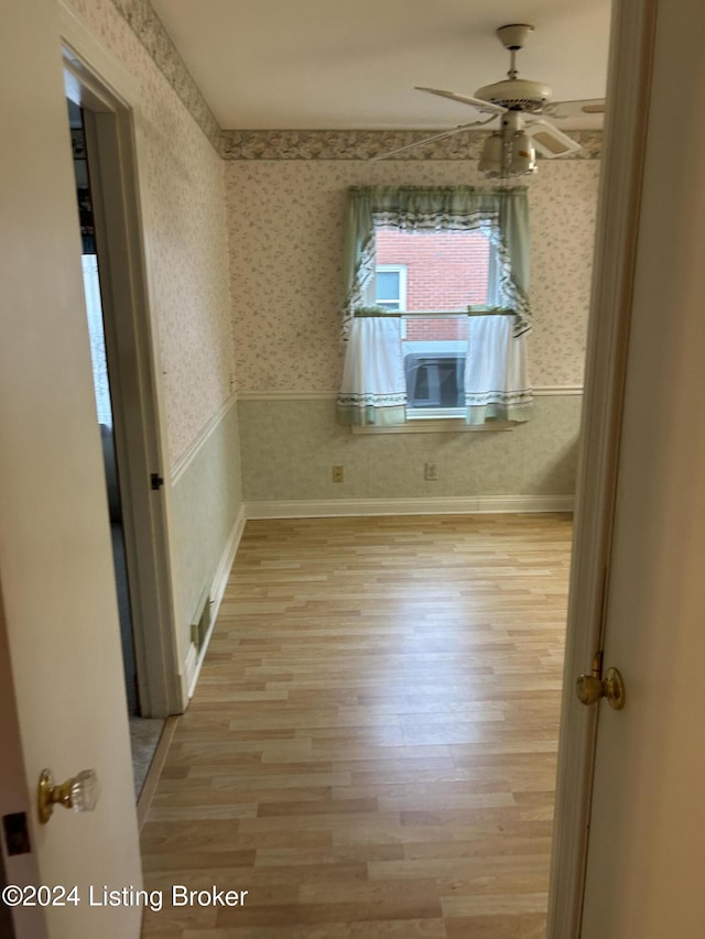 empty room with light wood-type flooring and ceiling fan