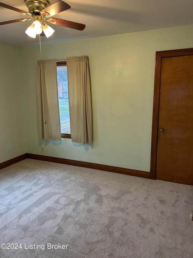 carpeted empty room featuring ceiling fan