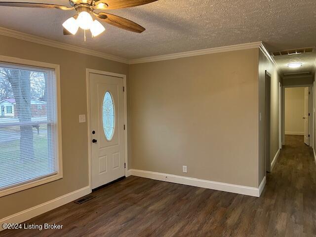 foyer entrance featuring crown molding, ceiling fan, dark wood-type flooring, and a textured ceiling