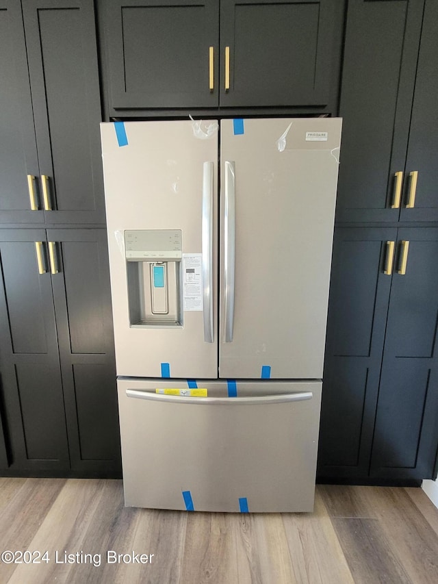 kitchen featuring stainless steel fridge and light hardwood / wood-style flooring