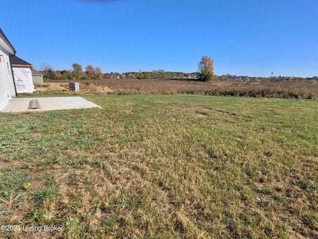 view of yard with a rural view and a patio area