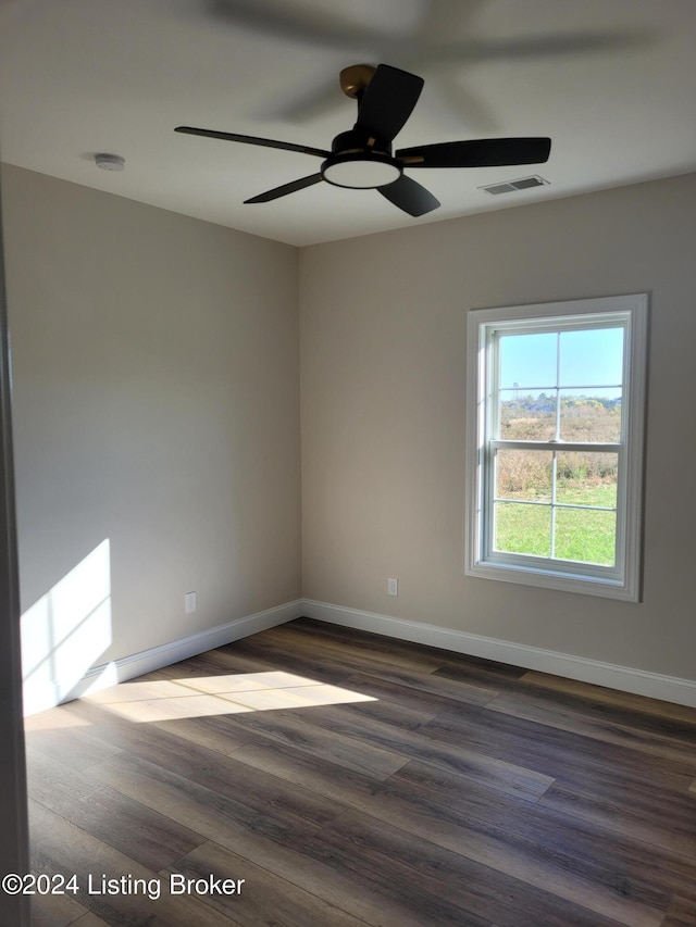 spare room with dark wood-type flooring and ceiling fan